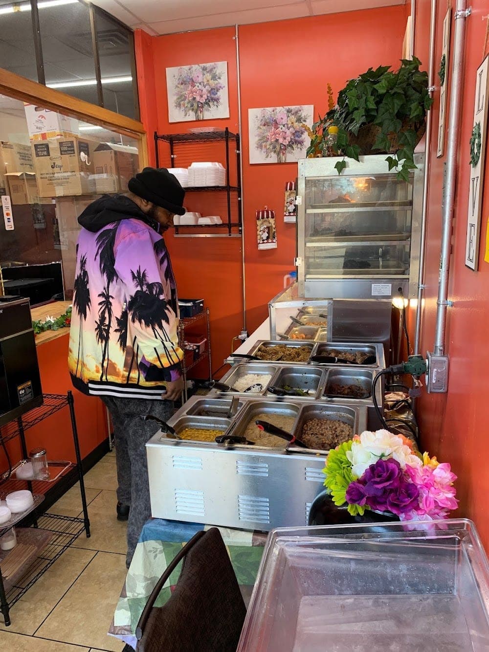 Customer at the Zion Delight self-serve buffet — orange walls, steam trays full of soul food, Atlanta